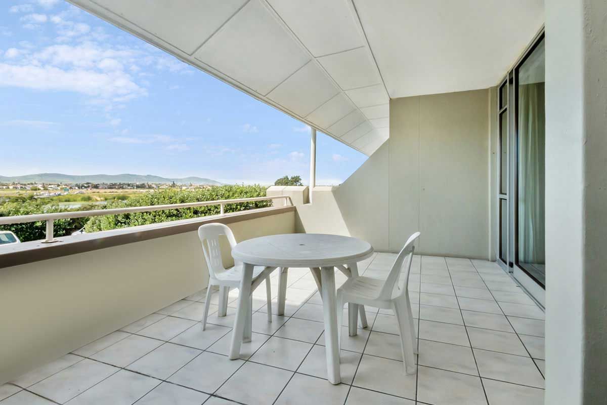 Ein Balkon mit Tisch und Stühlen