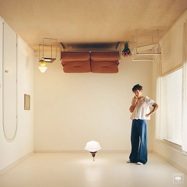 A woman is standing in a room with a couch upside down