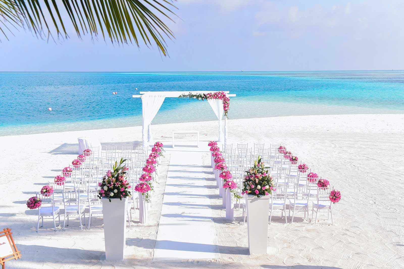 A wedding ceremony is set up on a tropical beach.