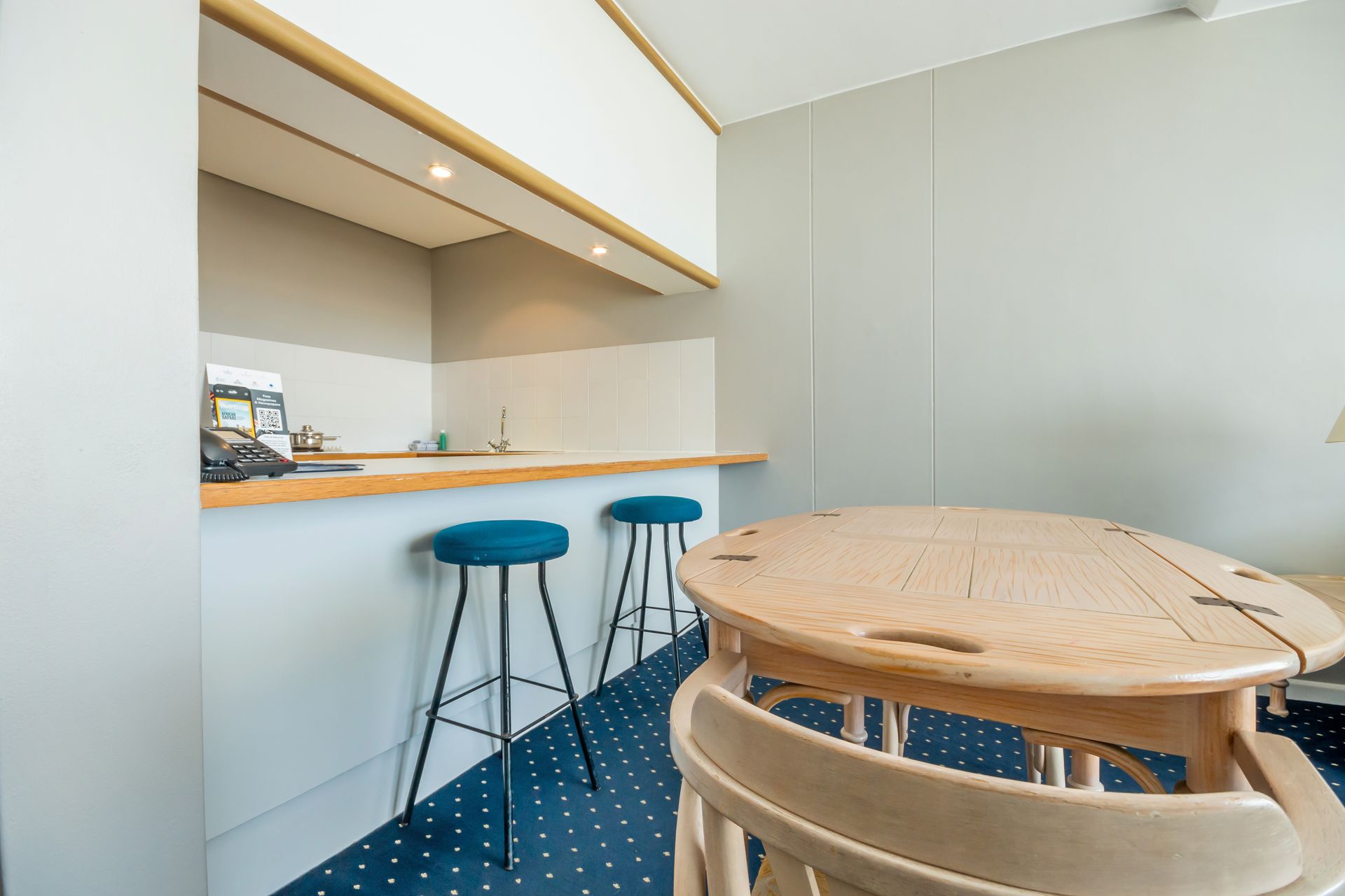 A kitchen with a table , chairs and stools.