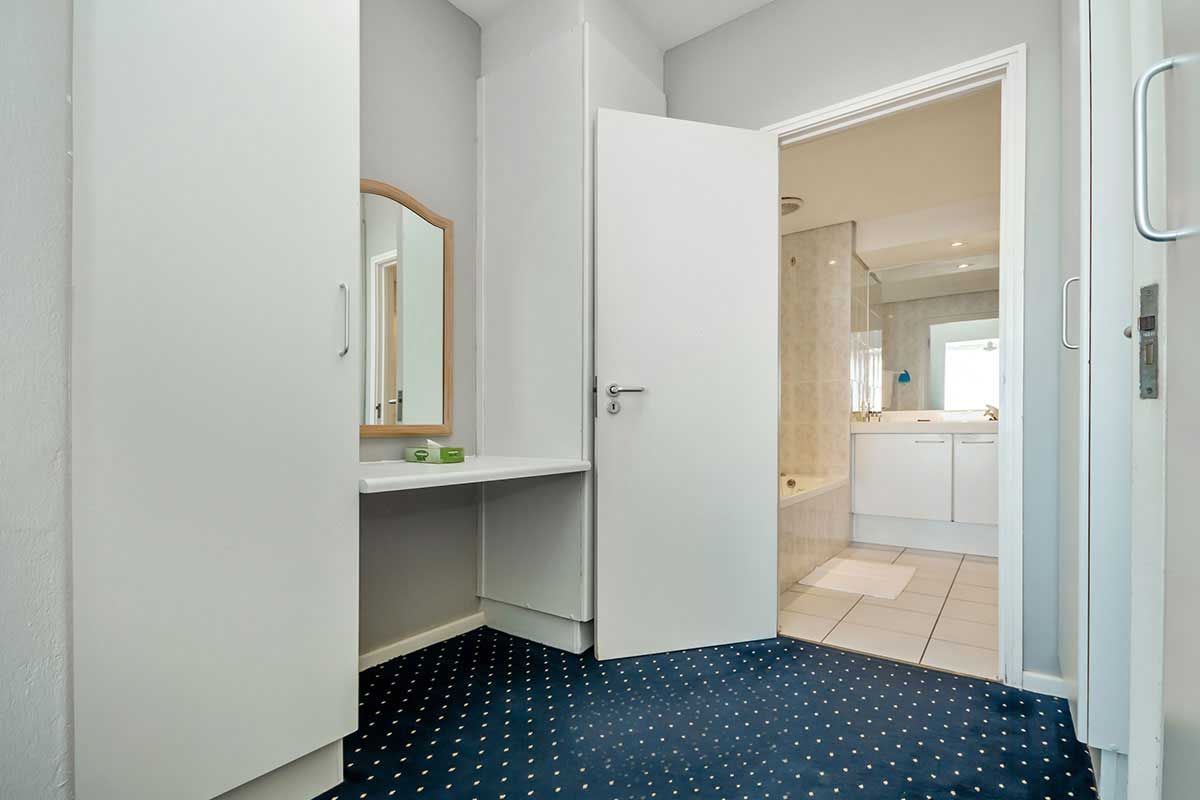 Ein Hotelzimmer mit einem blauen Teppich und einem Spiegel.