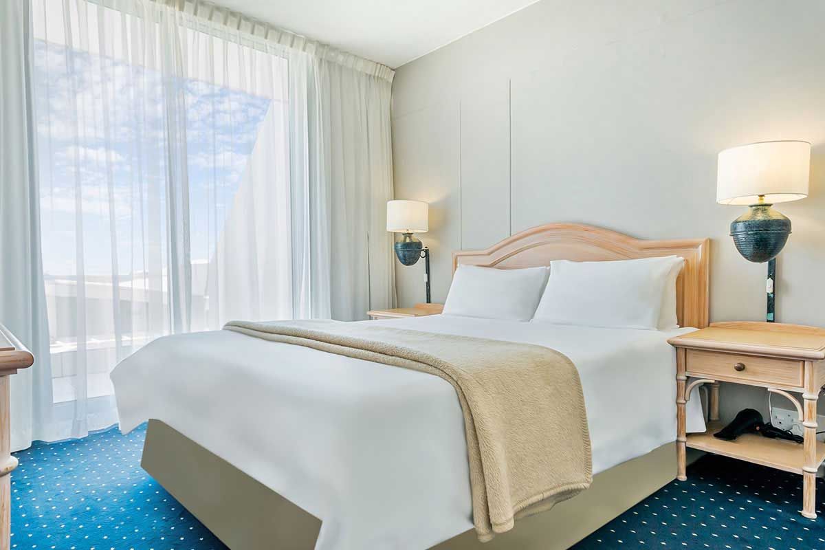 Ein Hotelzimmer mit einem Kingsize-Bett und einem blauen Teppich.