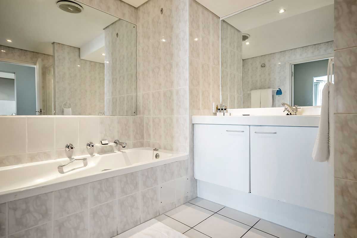 Ein Badezimmer mit Badewanne, Waschbecken und Spiegel.