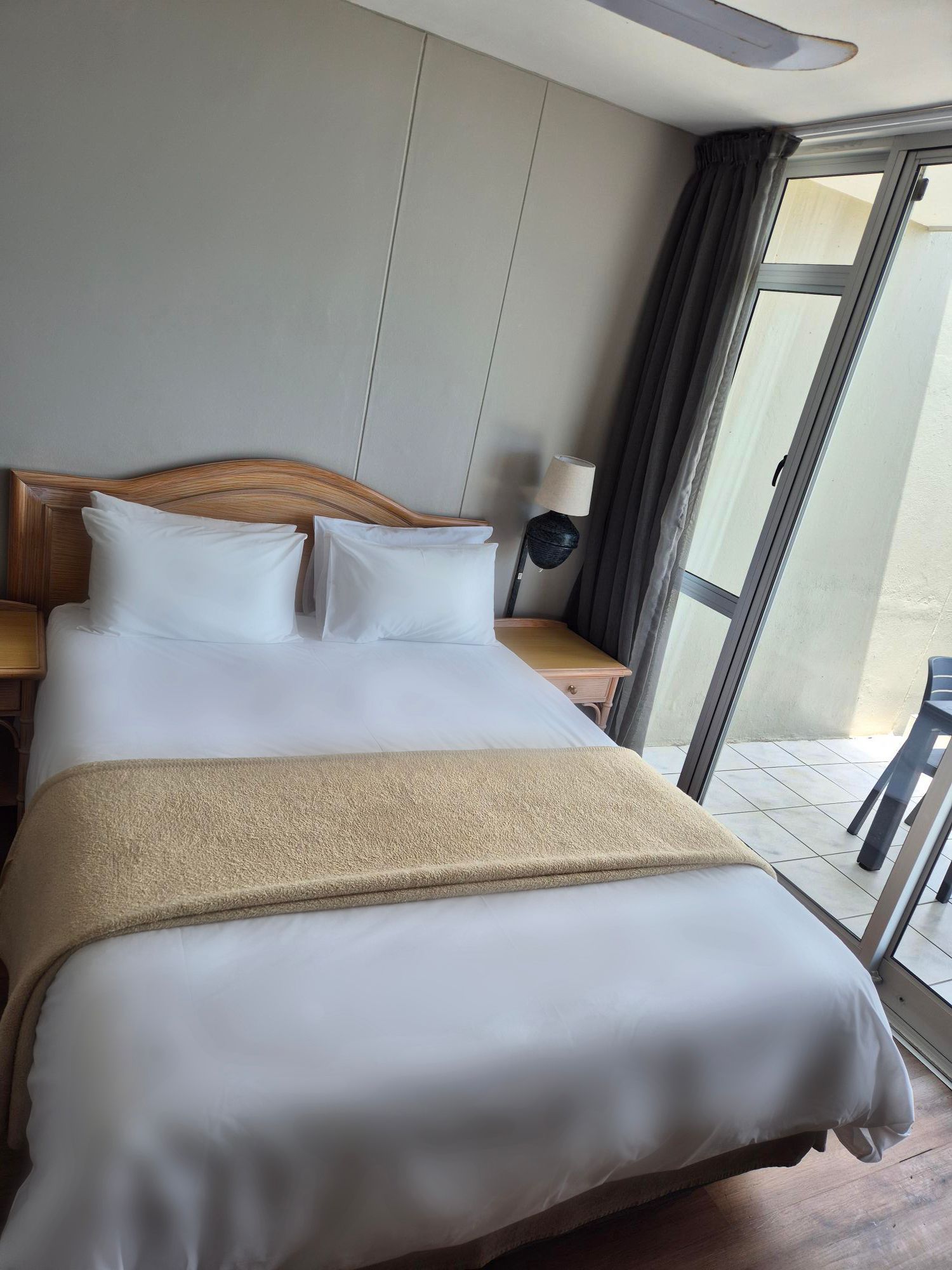 Een hotelkamer met een kingsize bed en een balkon.