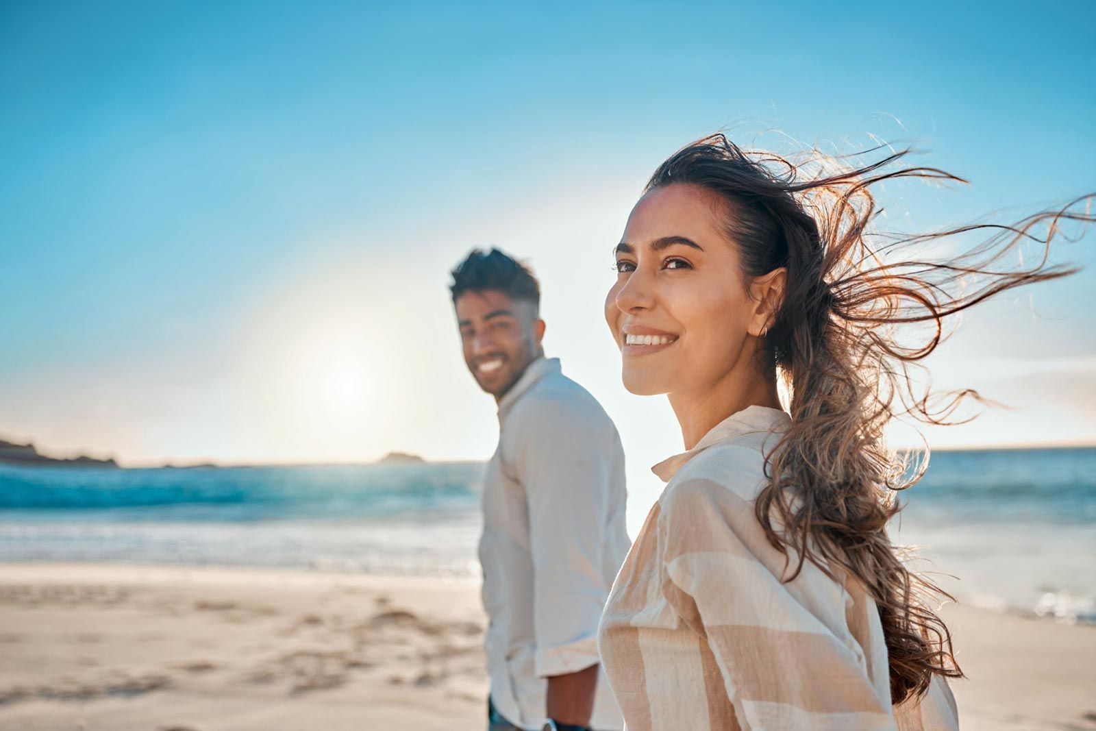 Ein Mann und eine Frau gehen am Strand spazieren.