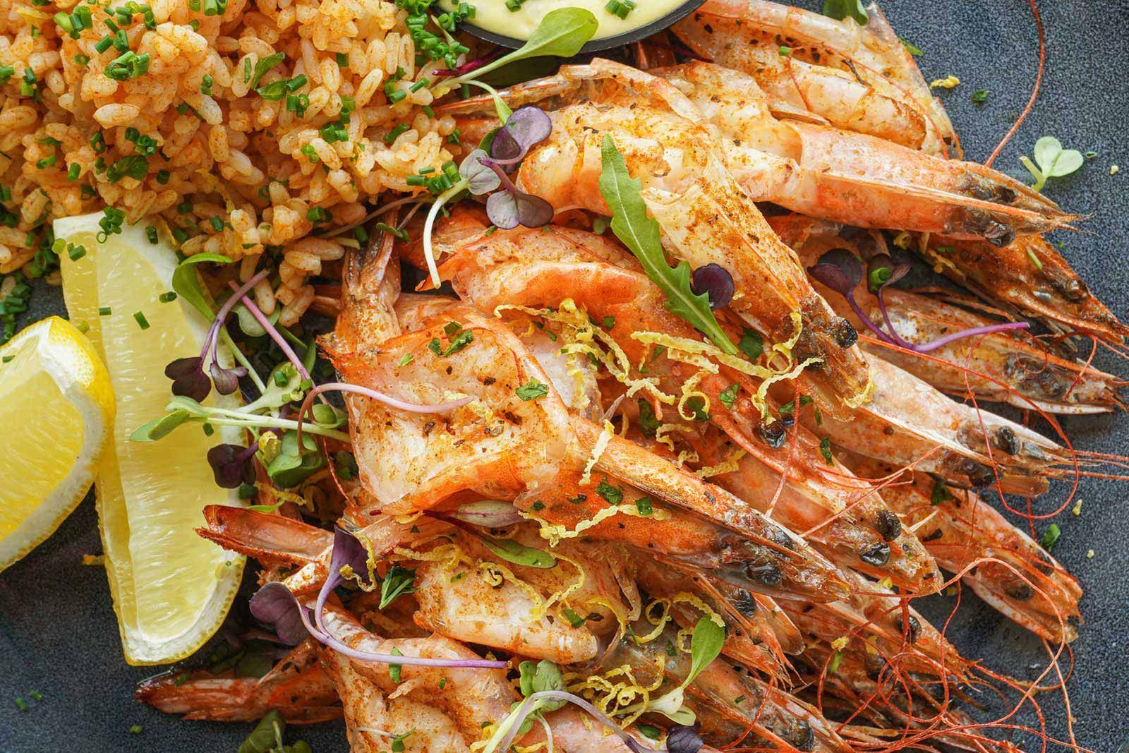 A close up of a plate of food with shrimp and rice.