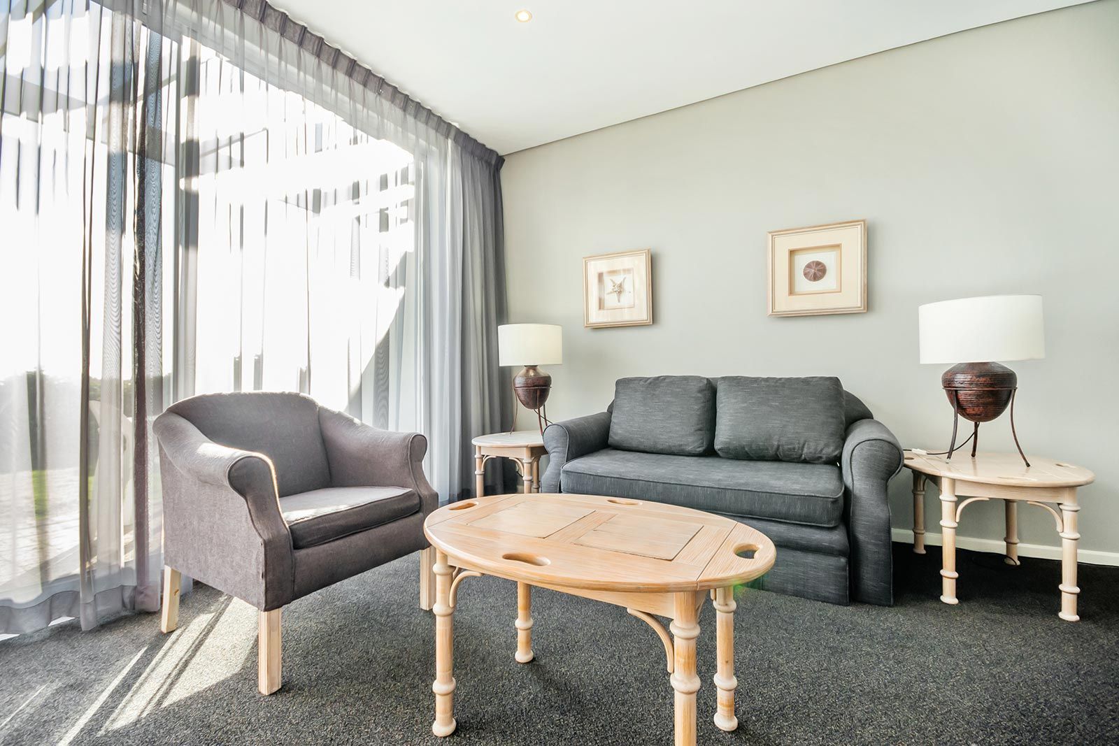 A living room with a couch , chairs , and a coffee table.