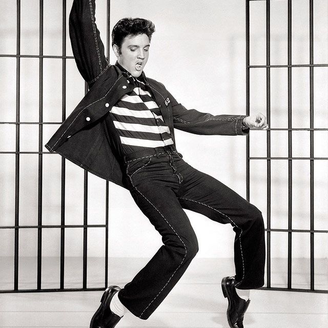 Een zwart-witfoto van elvis presley die danst