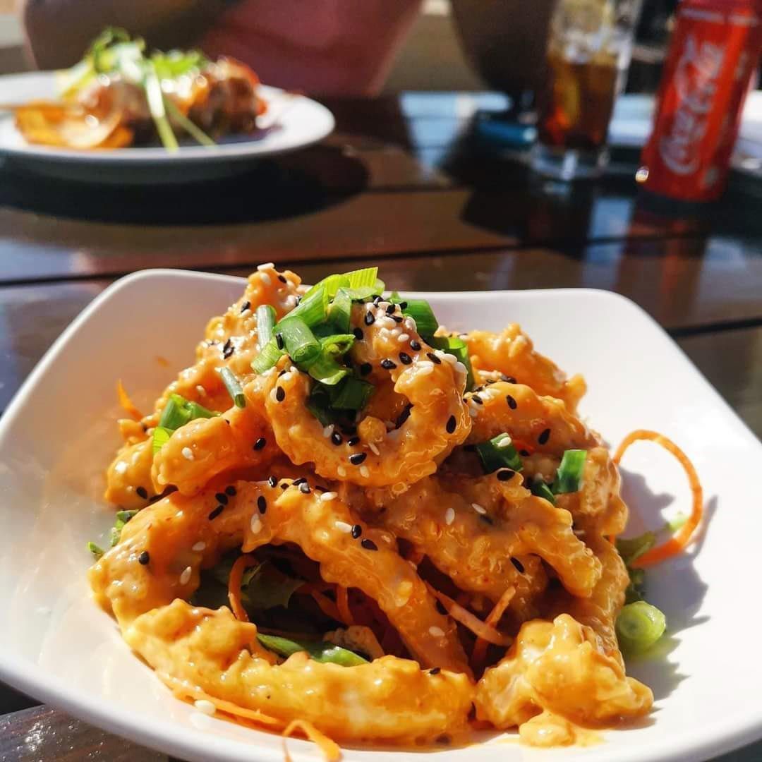 Un plato de comida con una lata de Coca Cola al fondo.