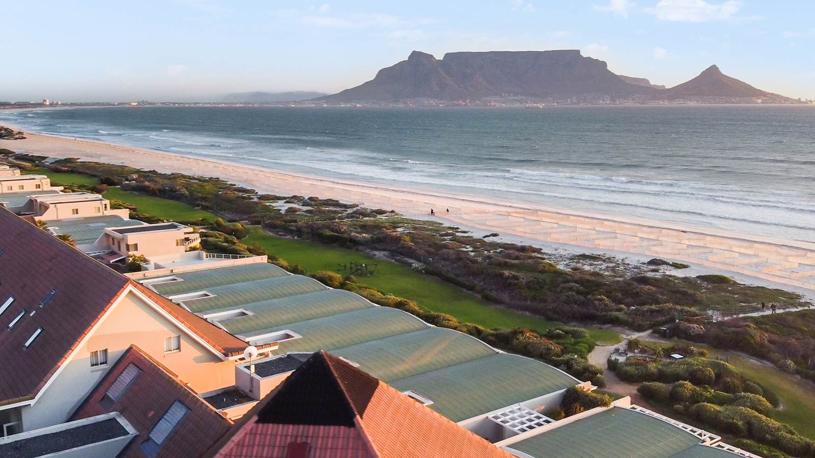 An aerial view of a beach with a mountain in the background