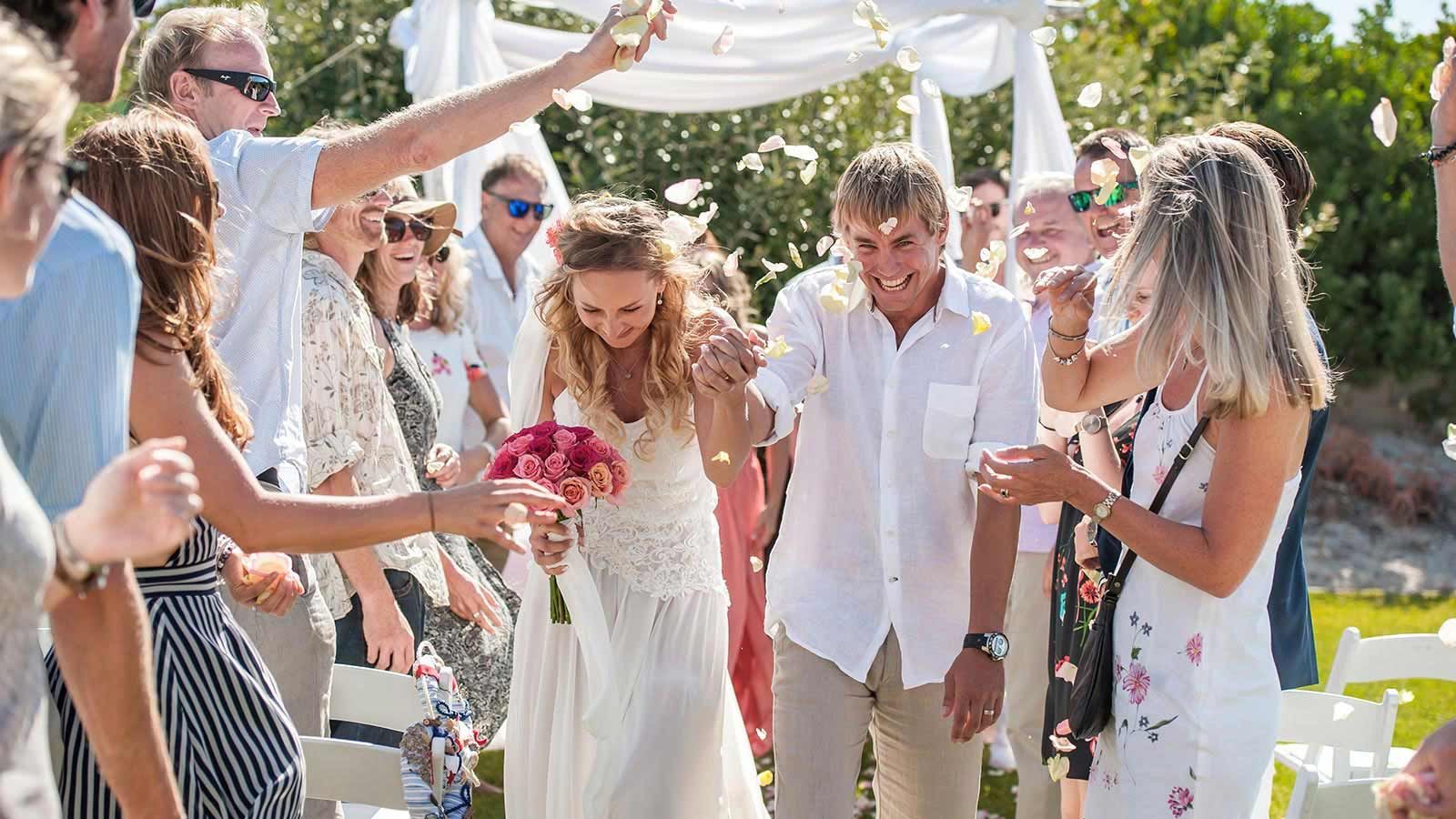 A bride and groom are walking down the aisle at their wedding.