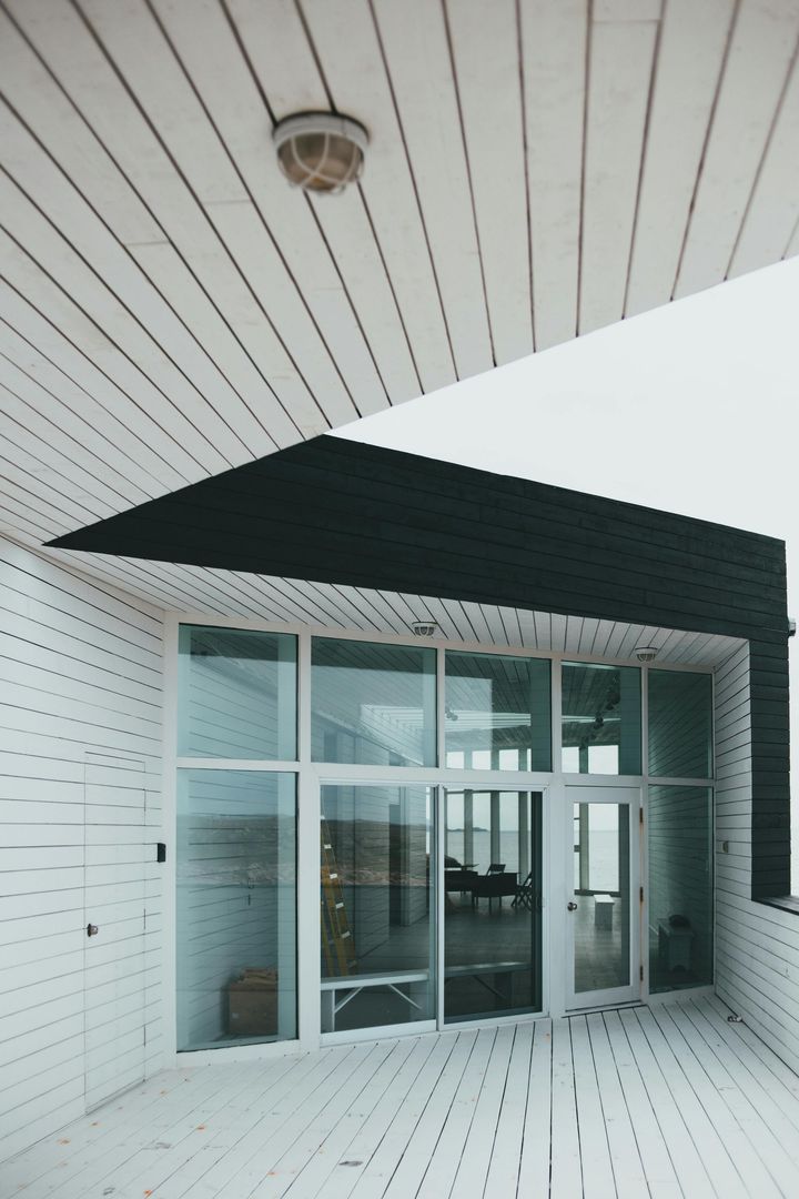 A white building with a black roof and a lot of windows