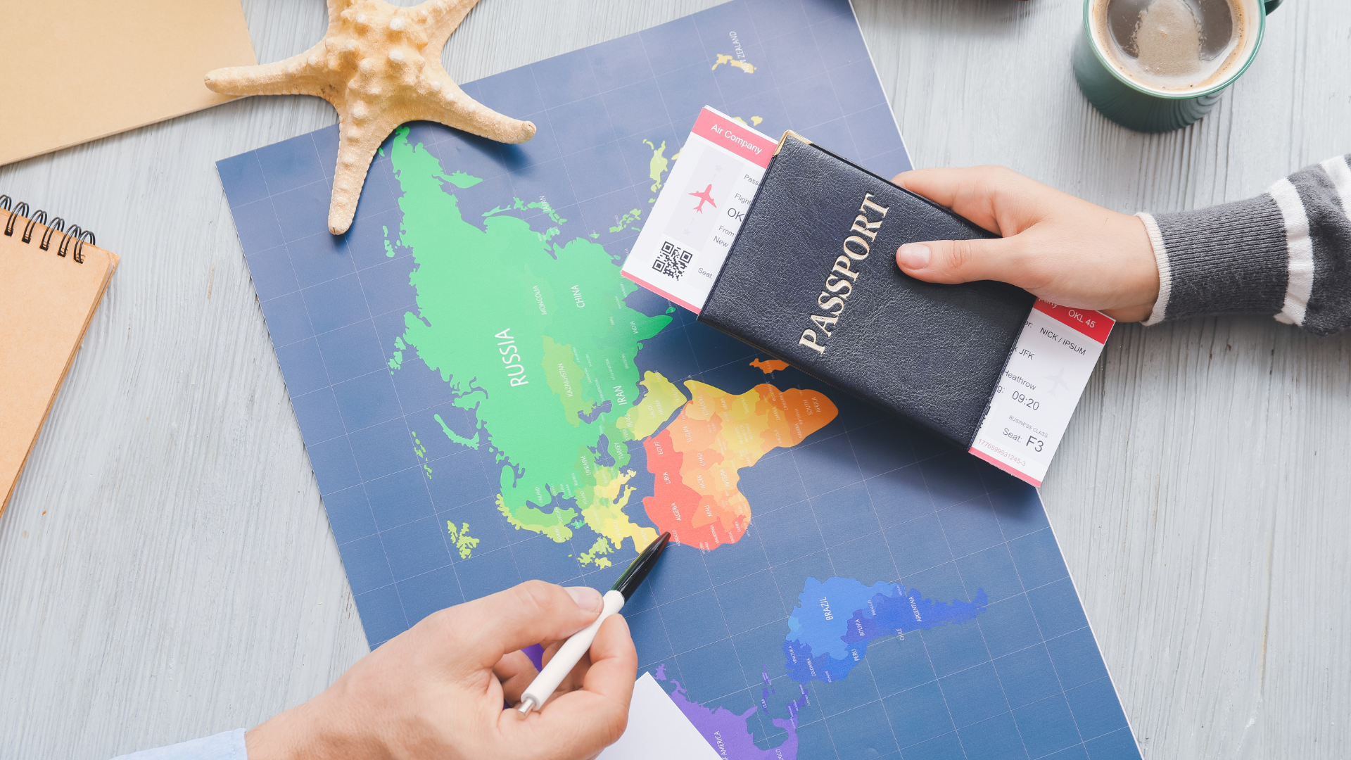 A person is holding a passport over a map of the world.