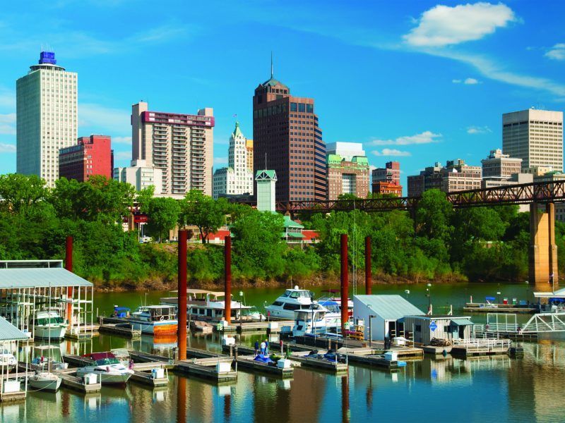 A marina with boats docked in front of a city skyline
