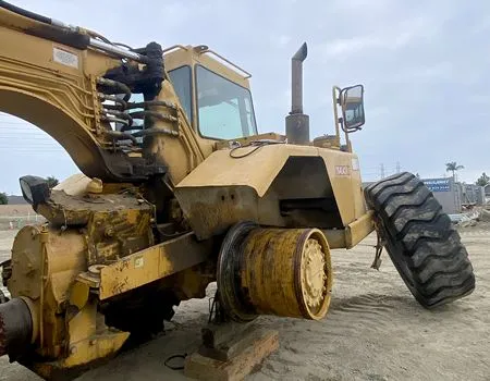 A yellow bulldozer is sitting on top of a dirt field.
