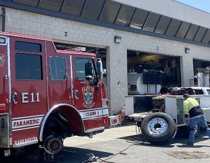 A man is working on a fire truck in a garage.