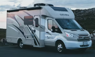 A white rv is parked in a parking lot.