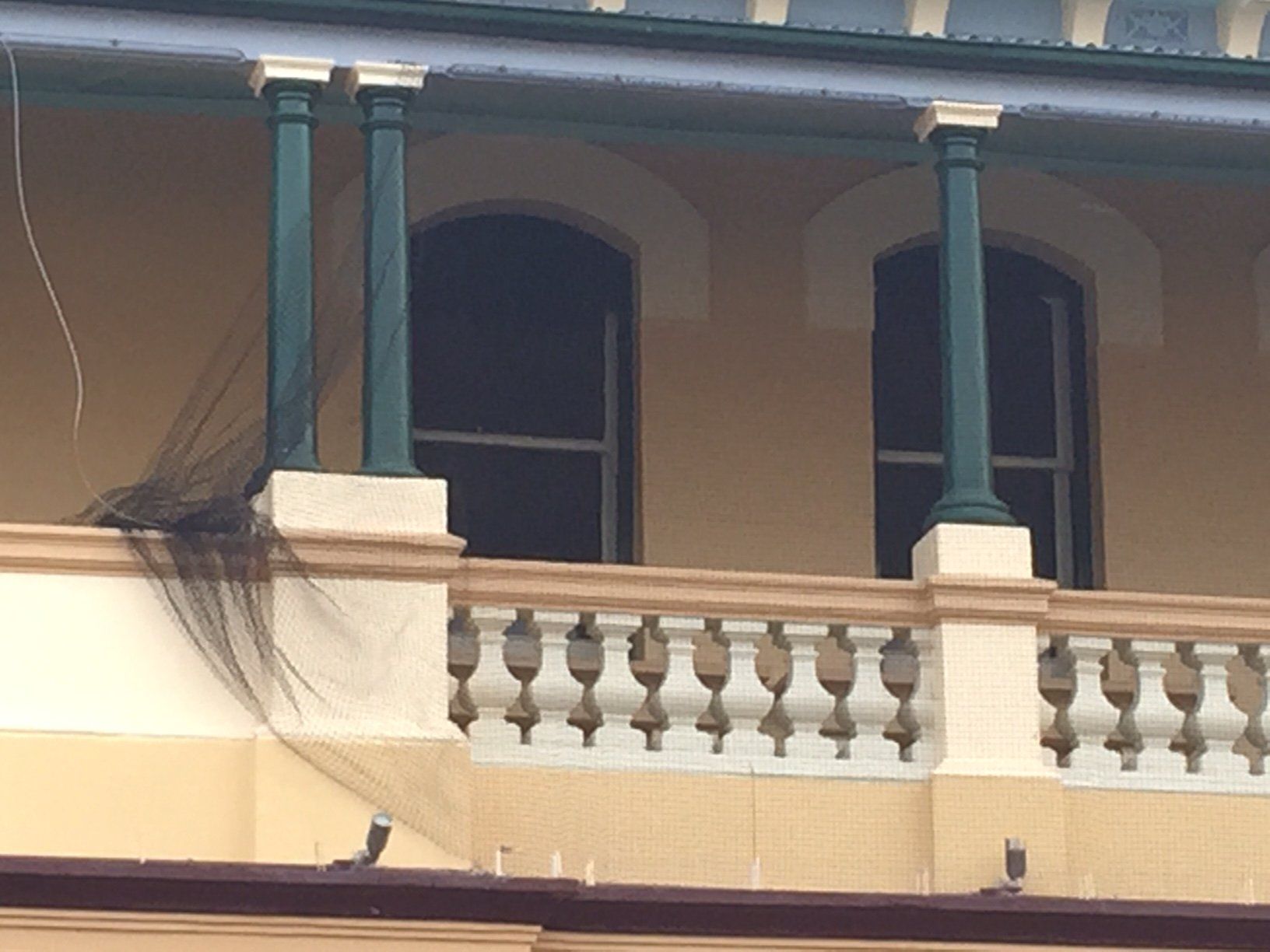 A balcony of a building with a bird on it