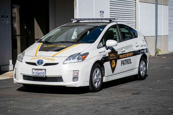 A white patrol car is parked in front of a building.