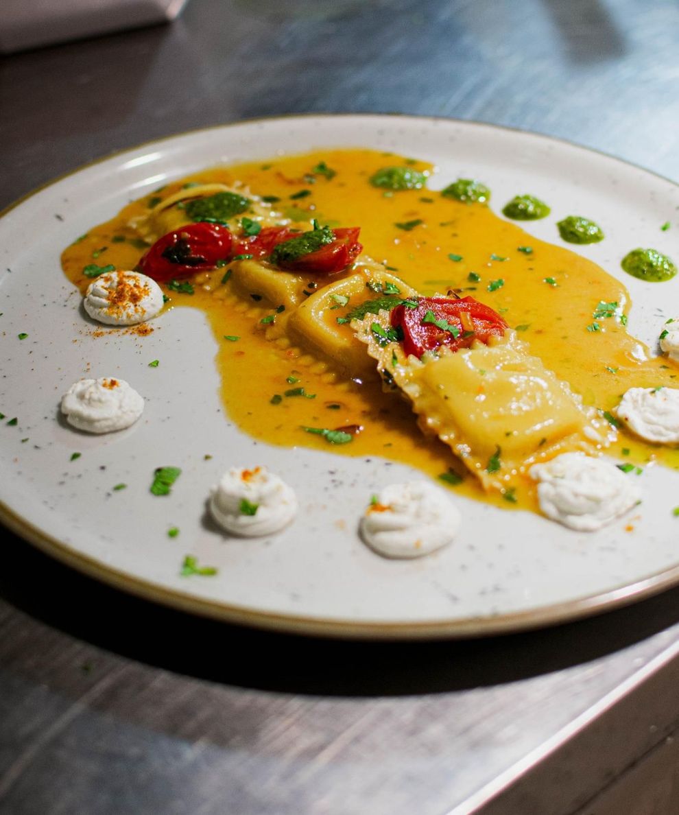 Tavolo da ristorante con piatti curati e luce calda serale.