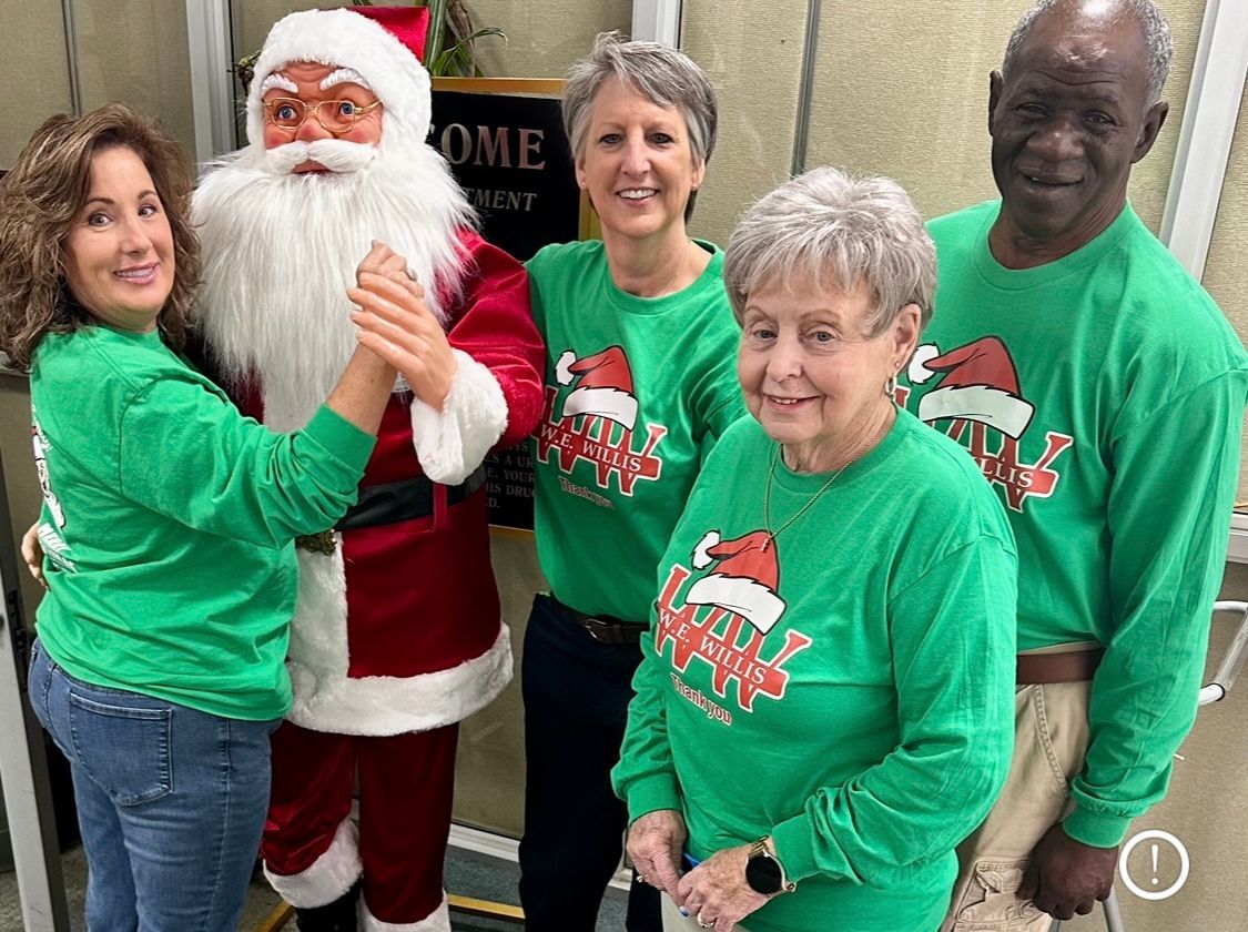 A group of people are posing for a picture with santa claus.