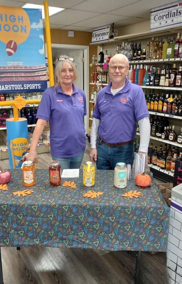 A man and a woman are standing in front of a table that says iron ad