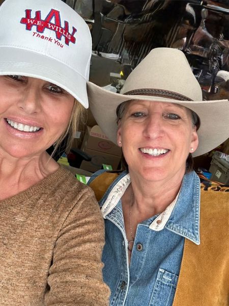 A man wearing sunglasses is holding a bottle of water.