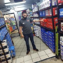 A man is standing in the middle of a grocery store.
