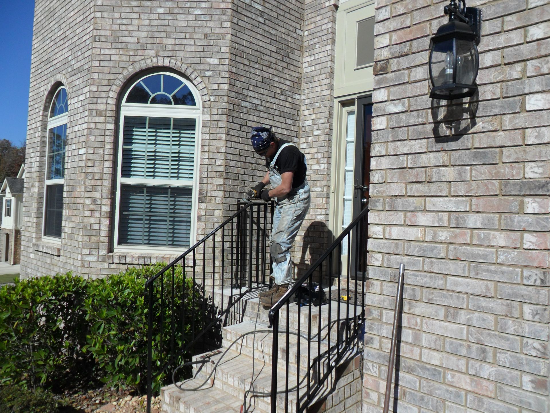 A man is standing on a set of stairs in front of a brick building.