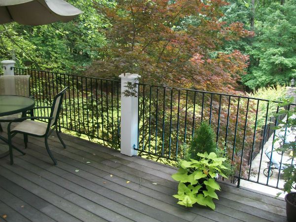 A deck with a table and chairs and potted plants