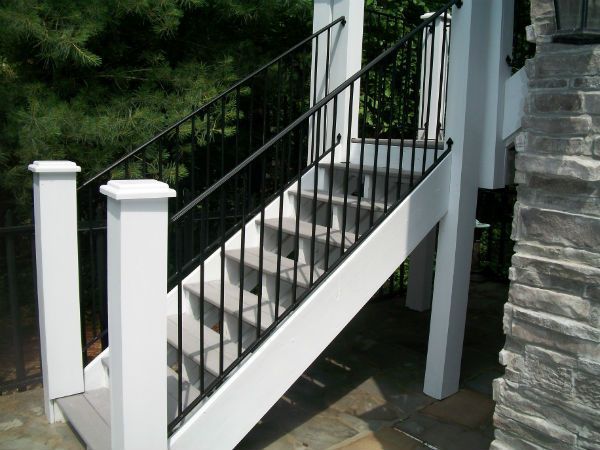 A set of white stairs with a black railing