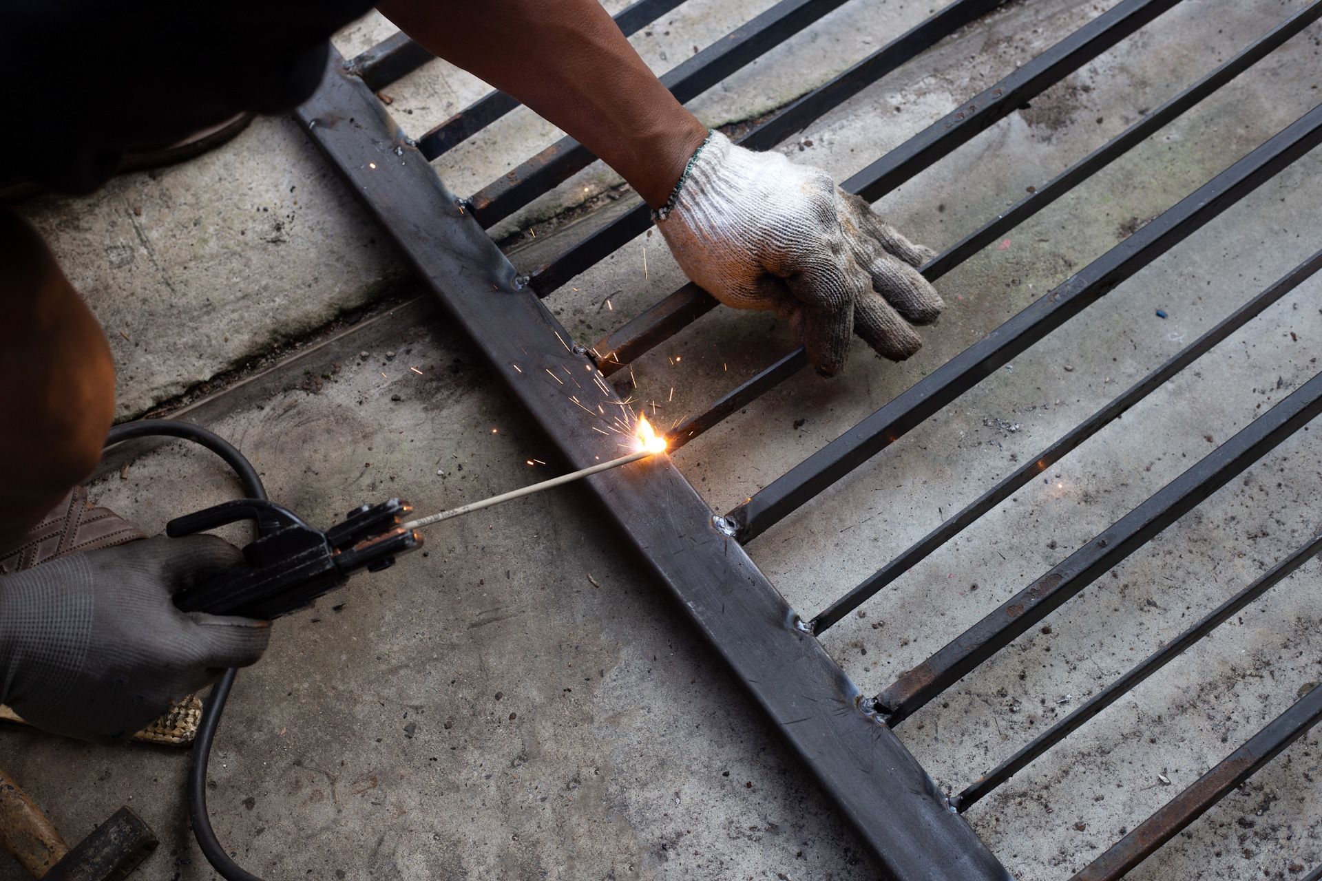 A person is welding a piece of metal with a welding machine.
