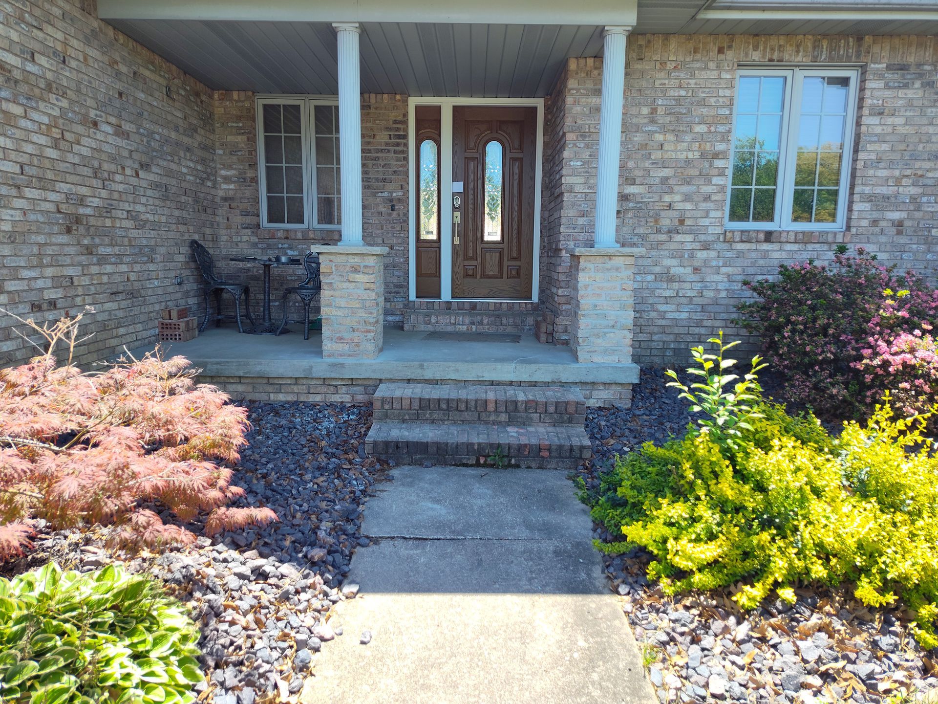 A brick house with a porch and steps leading to it