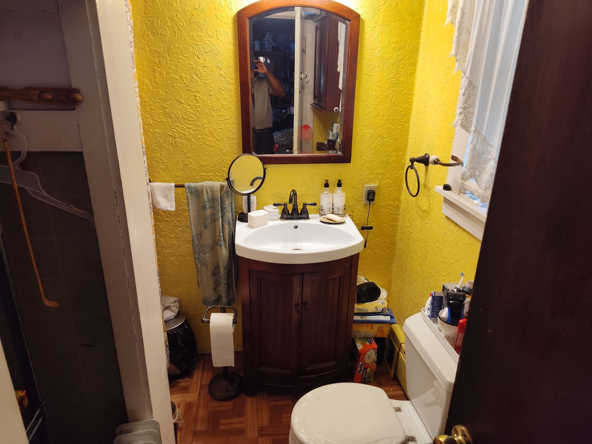 A bathroom with yellow walls and a sink and toilet