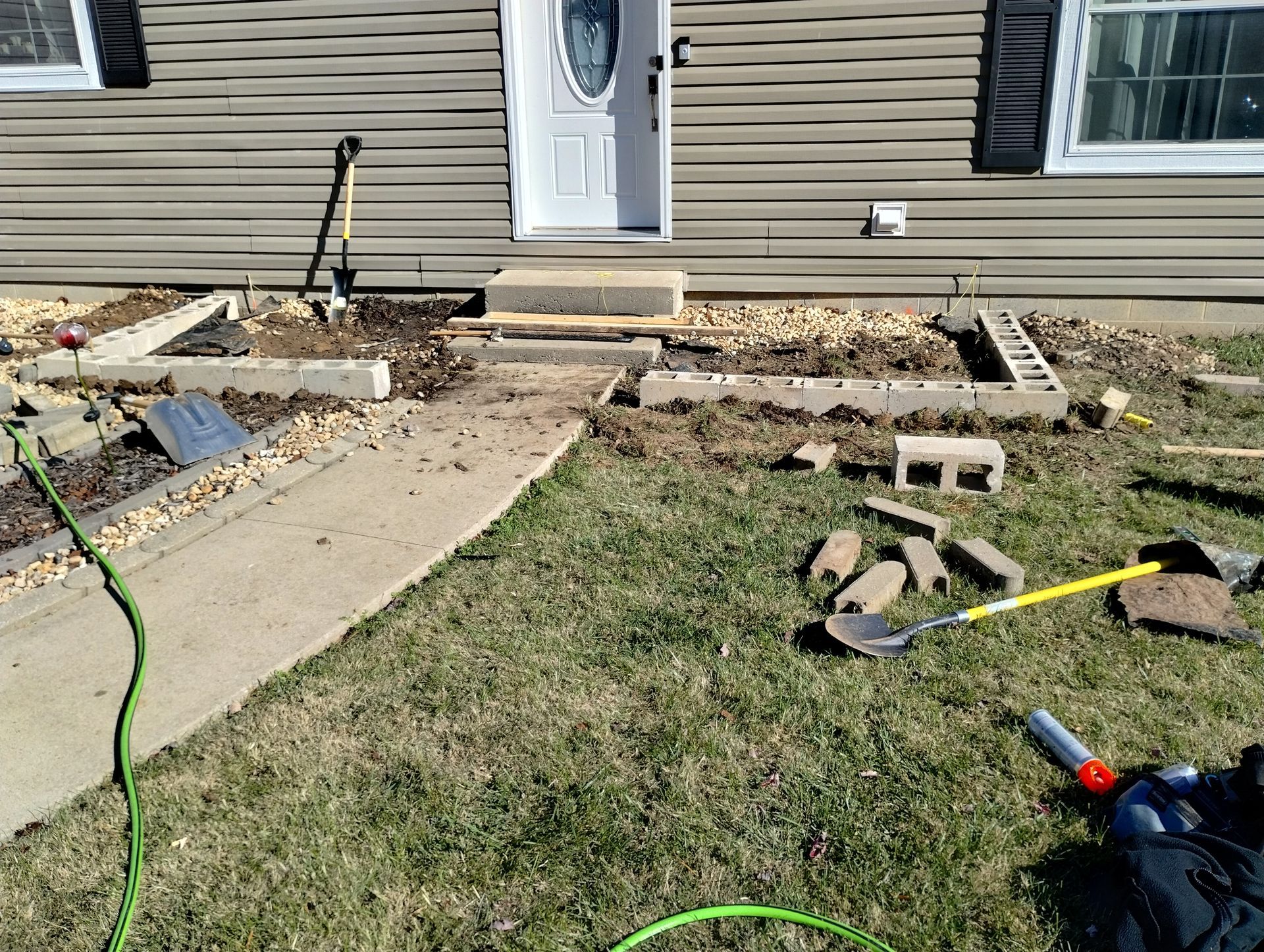 A person is working on a garden in front of a house.