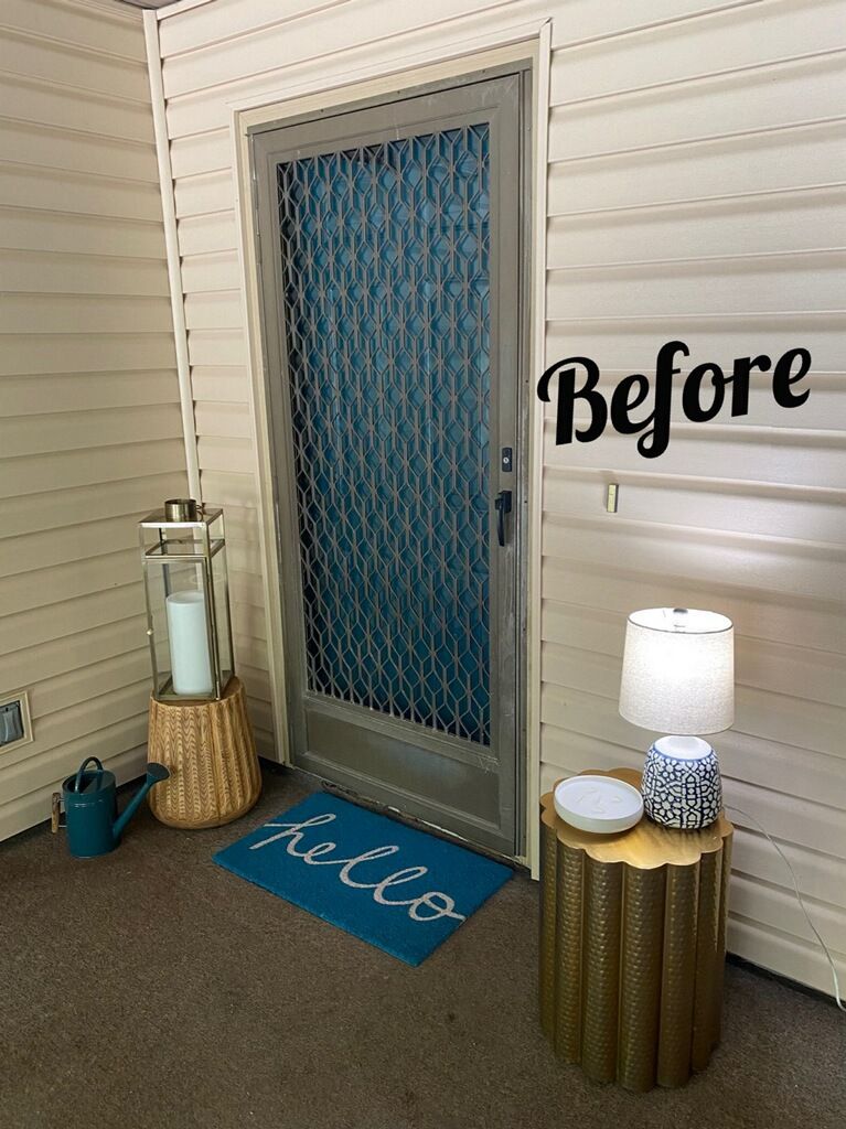 A before picture of a door with a blue mat and a lamp.