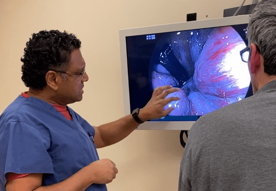 A doctor is holding a drawing of a large intestine in his hands.