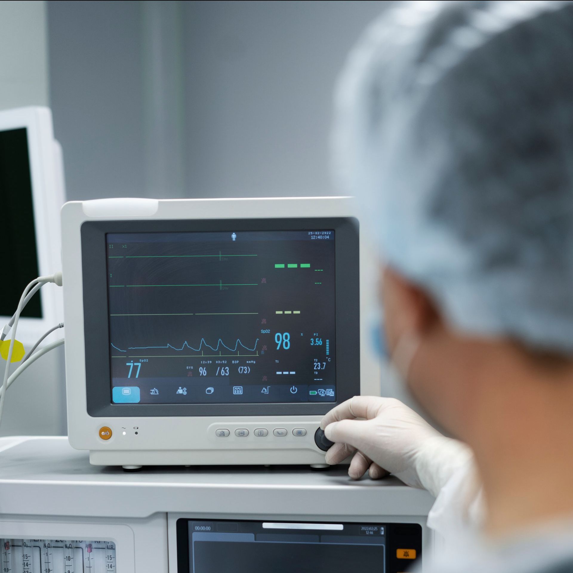 A surgeon is looking at a monitor in an operating room.