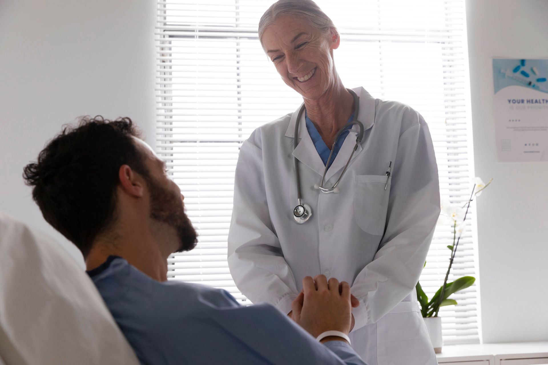 A doctor is talking to a patient in a hospital bed.