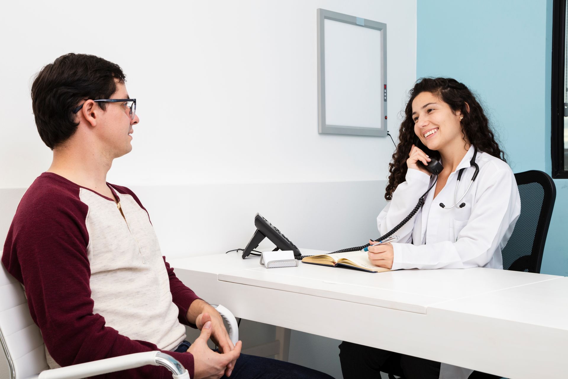 A doctor is talking on a phone to a patient.