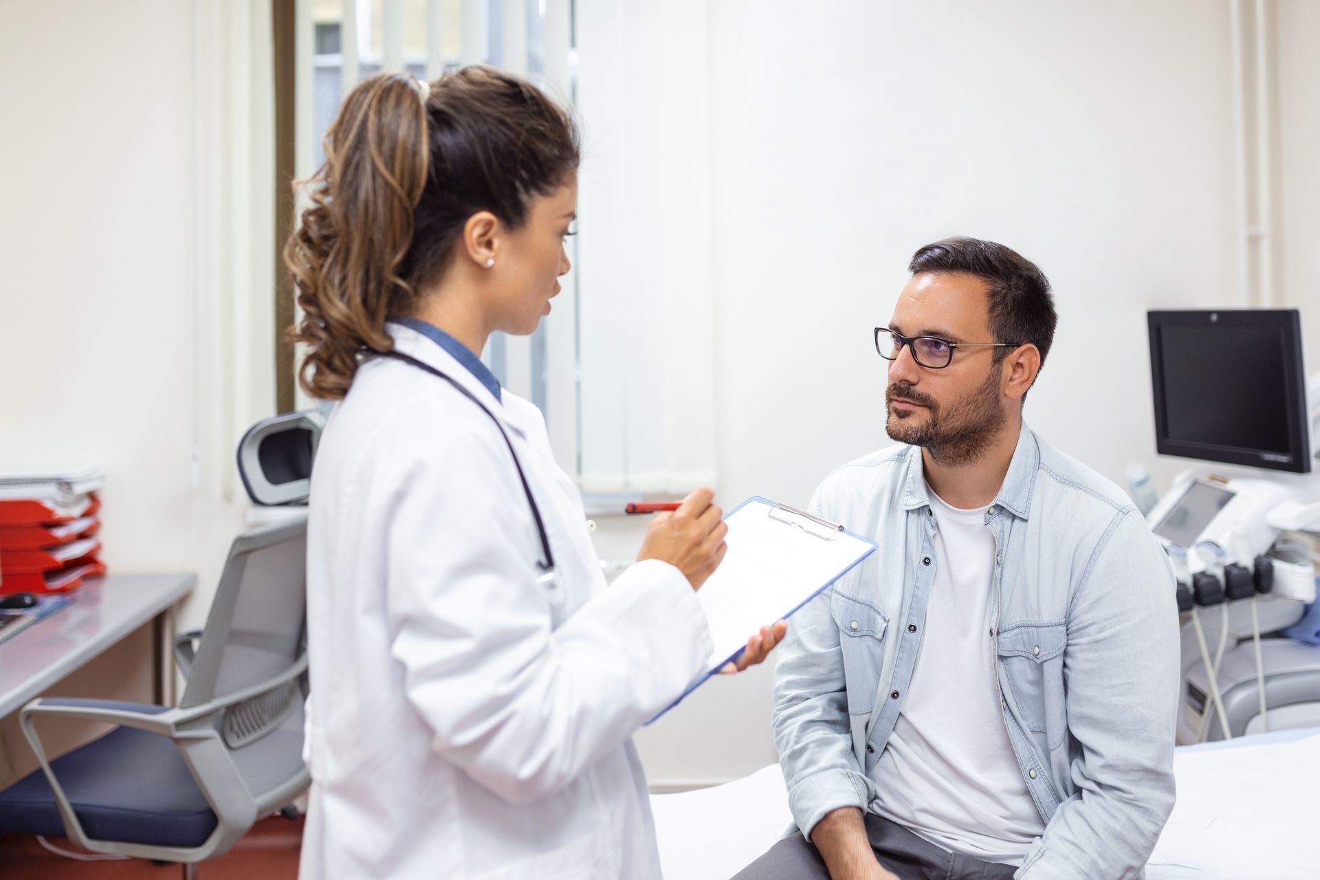 A doctor is talking to a patient in a hospital room.