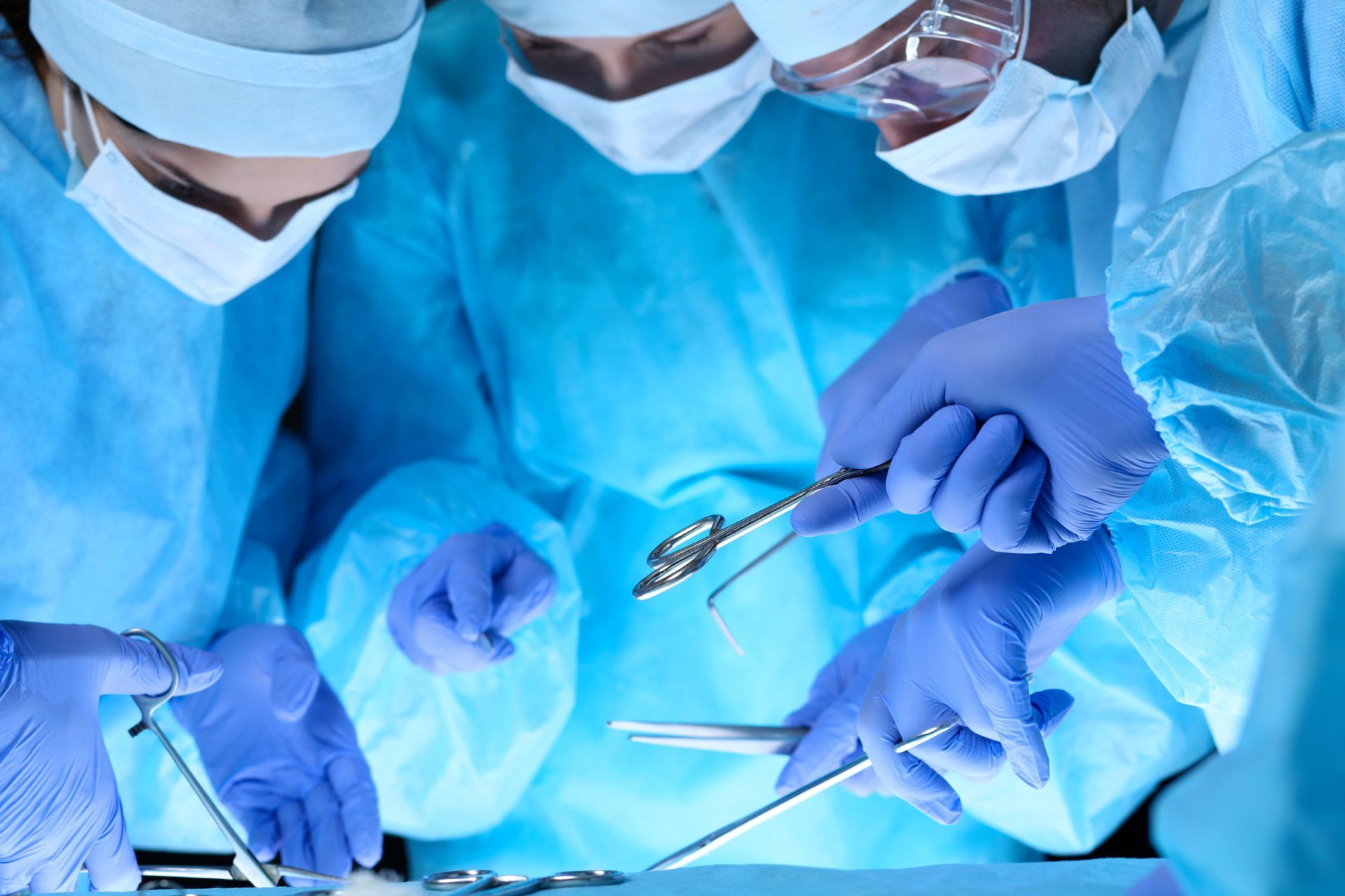 A group of surgeons are operating on a patient in an operating room.