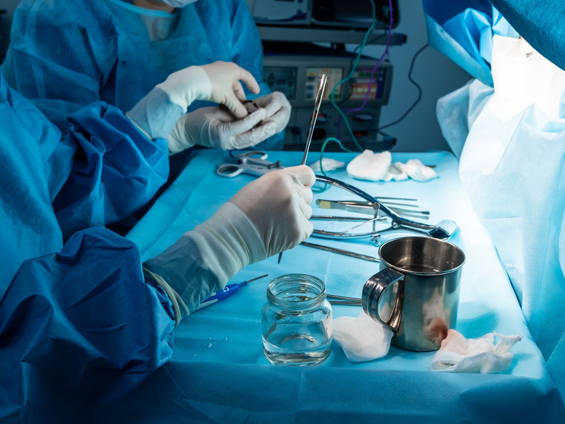 A group of surgeons are operating on a patient in an operating room.