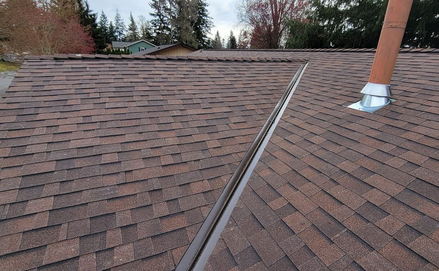 A roof with shingles and a chimney on it from Washington Roofing Services near Arlington WA