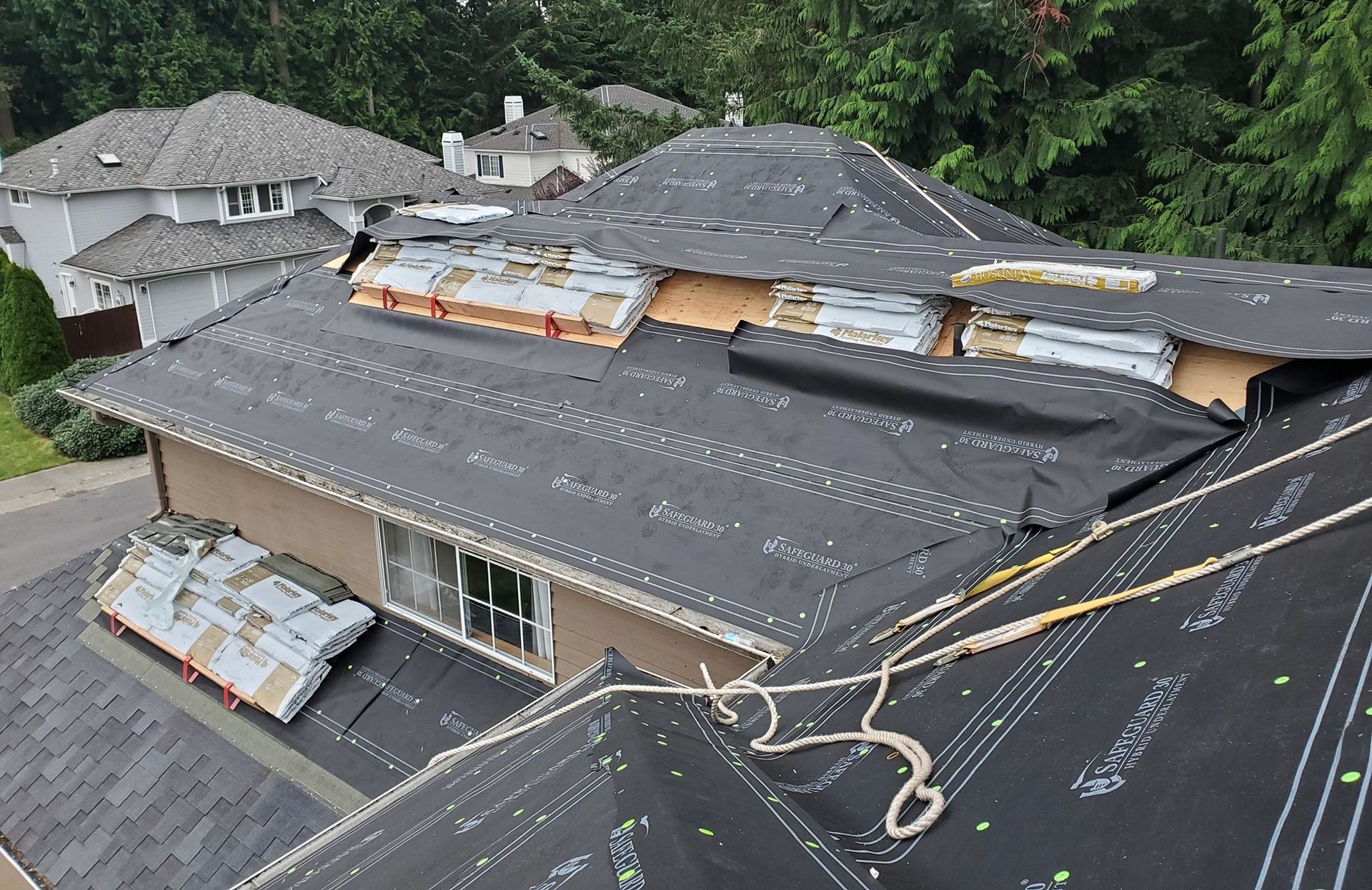 A house with a roof that is being repaired from Washington Roofing Services near Arlington WA