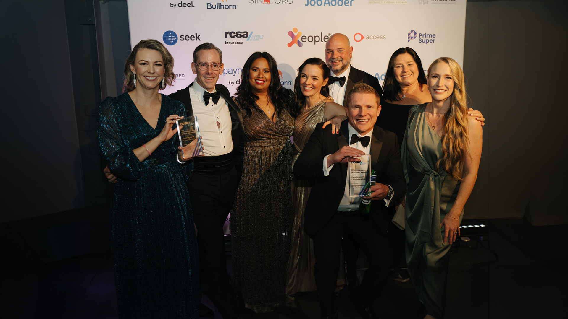 A group of people are posing for a picture at a awards ceremony.