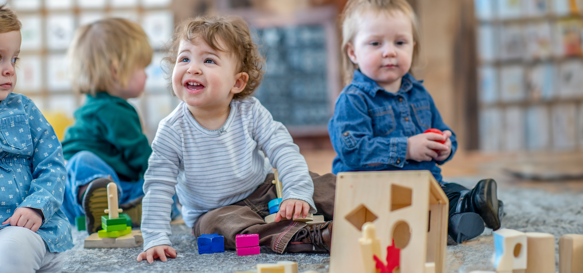 A child is playing with wooden blocks on a wooden table.