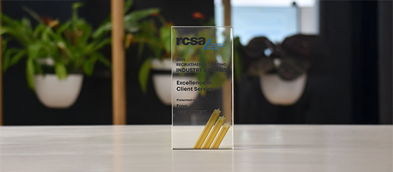 A fcsa trophy is sitting on a table in front of potted plants