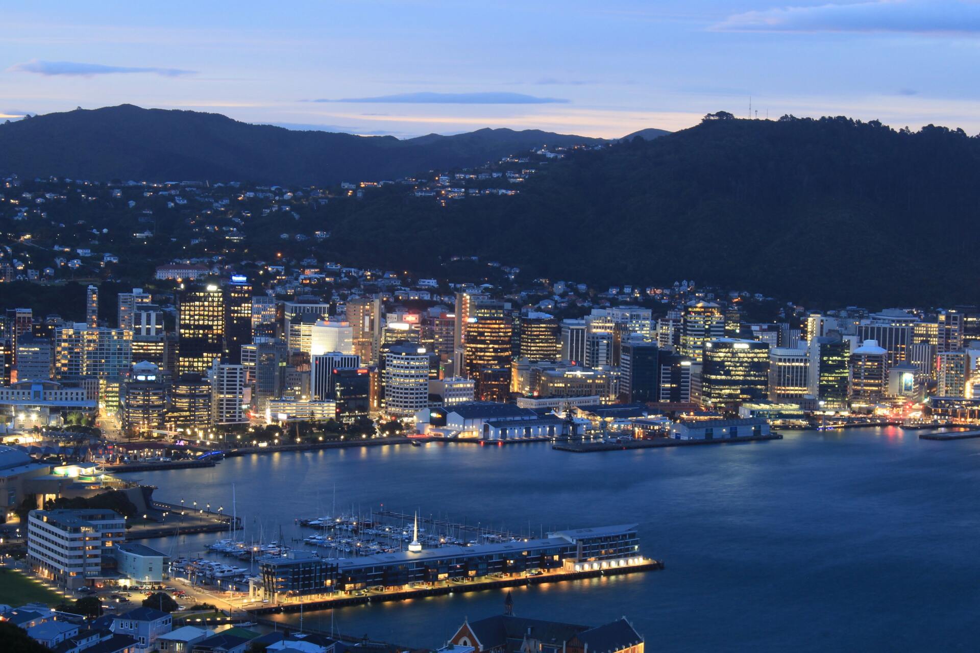 An aerial view of a city at night with mountains in the background