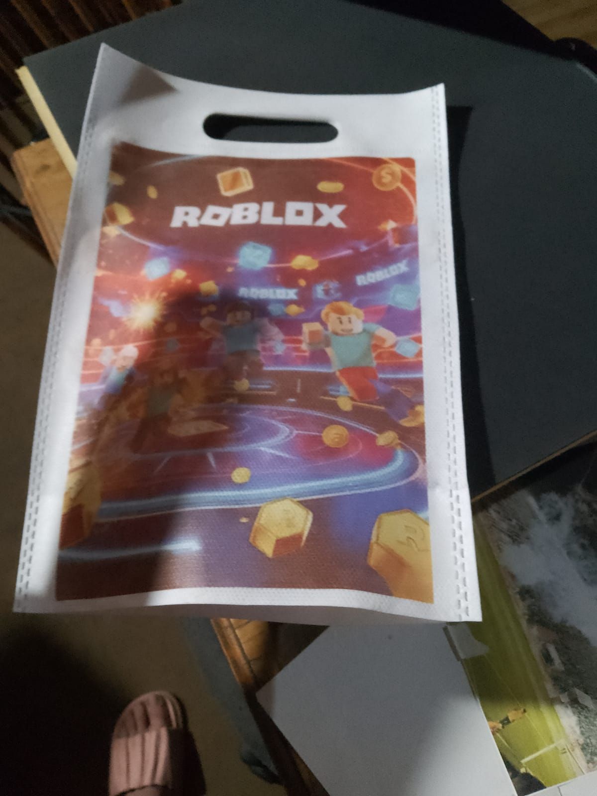 Bolsa de regalo de Roblox blanca con un gráfico de Roblox sobre una mesa.